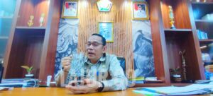 Basiran menggunakan gelas dibanding botol air mineral kemasan plastik menjamu tamu di ruangannya.